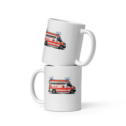 Lustige weiße Tasse mit Comic-Rettungswagen und dem Spruch „Nutzniesserfahrzeug“ in schwarzer und roter Schrift.