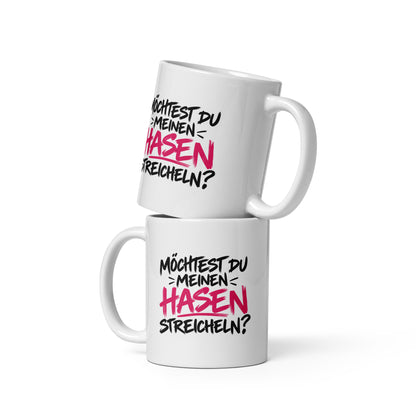 Lustige weiße Tasse mit dem frechen Spruch „Möchtest du meinen Hasen streicheln?“ in schwarzer und pinker Schrift.
