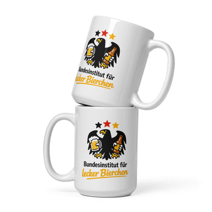Schwarze Tasse mit goldenem Adler, der ein Bier und eine Bierflasche hält, und dem Schriftzug Bundesinstitut für lecker Bierchen.