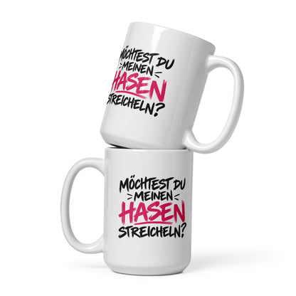 Lustige weiße Tasse mit dem frechen Spruch „Möchtest du meinen Hasen streicheln?“ in schwarzer und pinker Schrift.