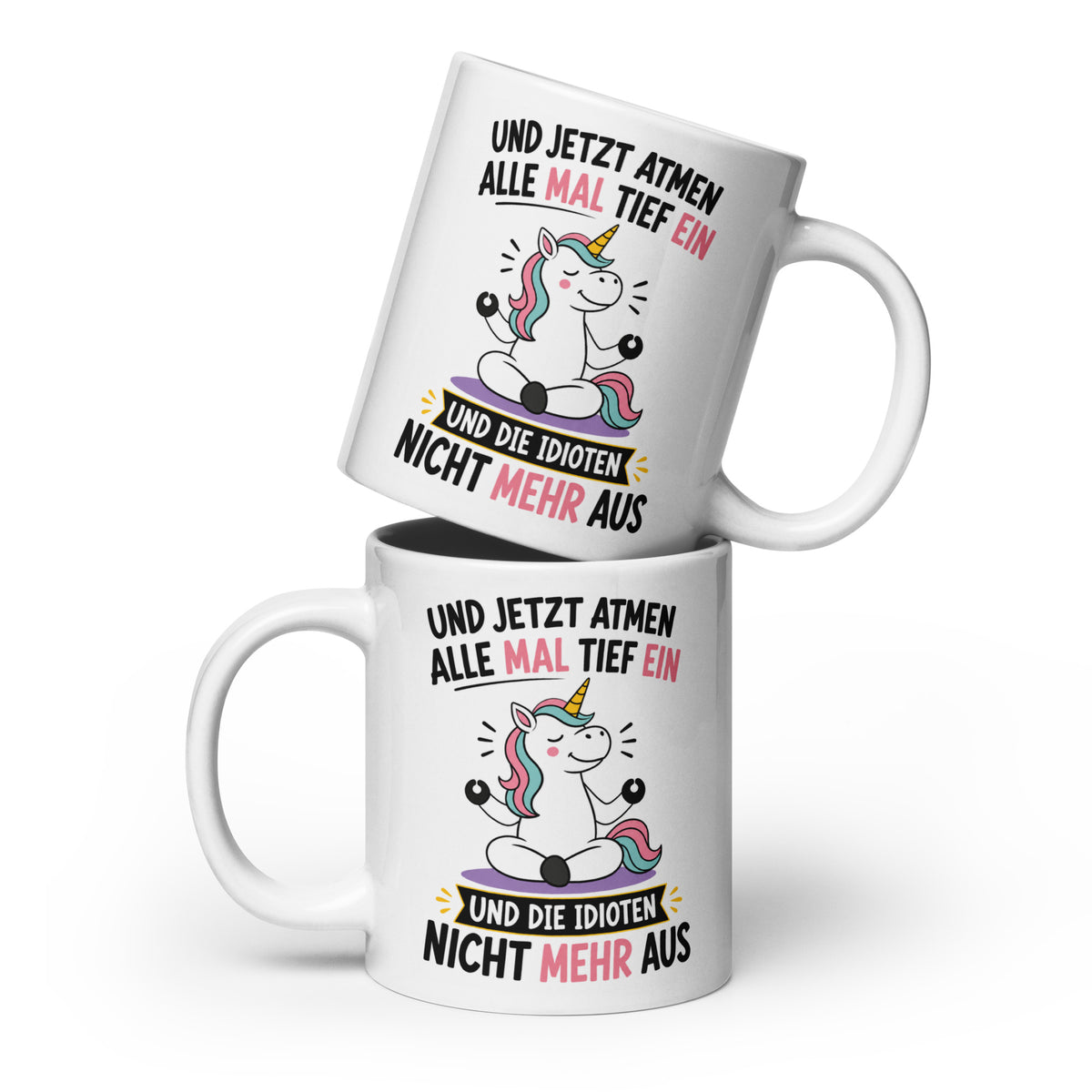 Weiße Keramiktasse mit einem meditierenden Einhorn und dem lustigen Spruch „Und jetzt atmen alle mal tief ein und die Idioten nicht mehr aus“ in schwarzer und pinker Schrift.